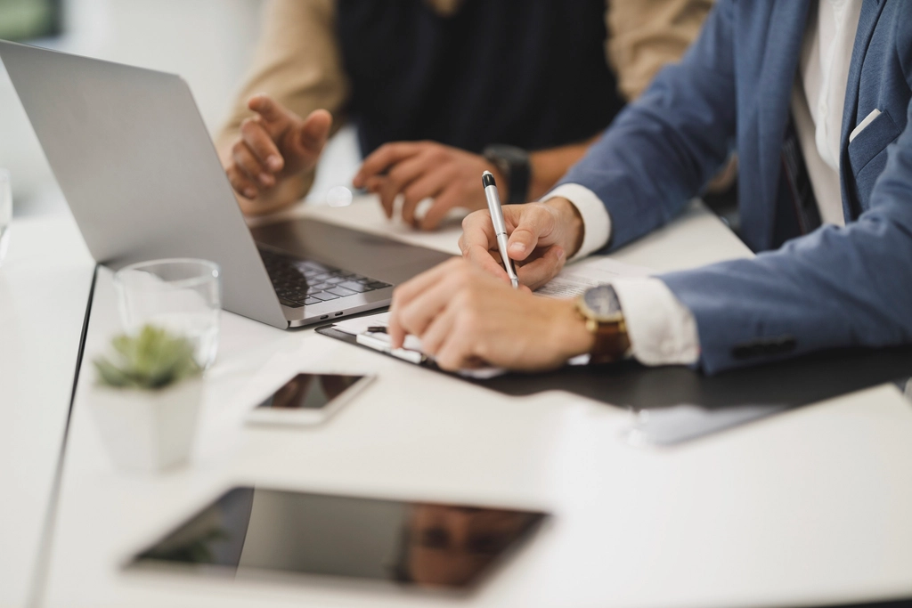 Deux professionnels examinent les documents d'une cession de clientèle.
