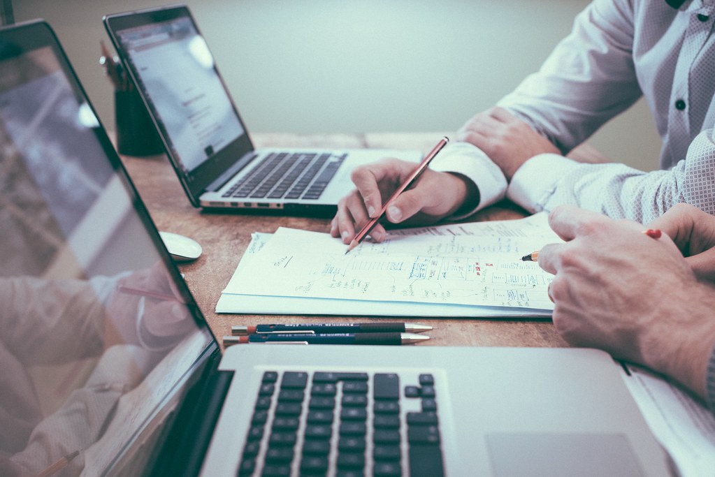 Deux dirigeants étudient un projet de rachat d'entreprise autour d'un ordinateur.